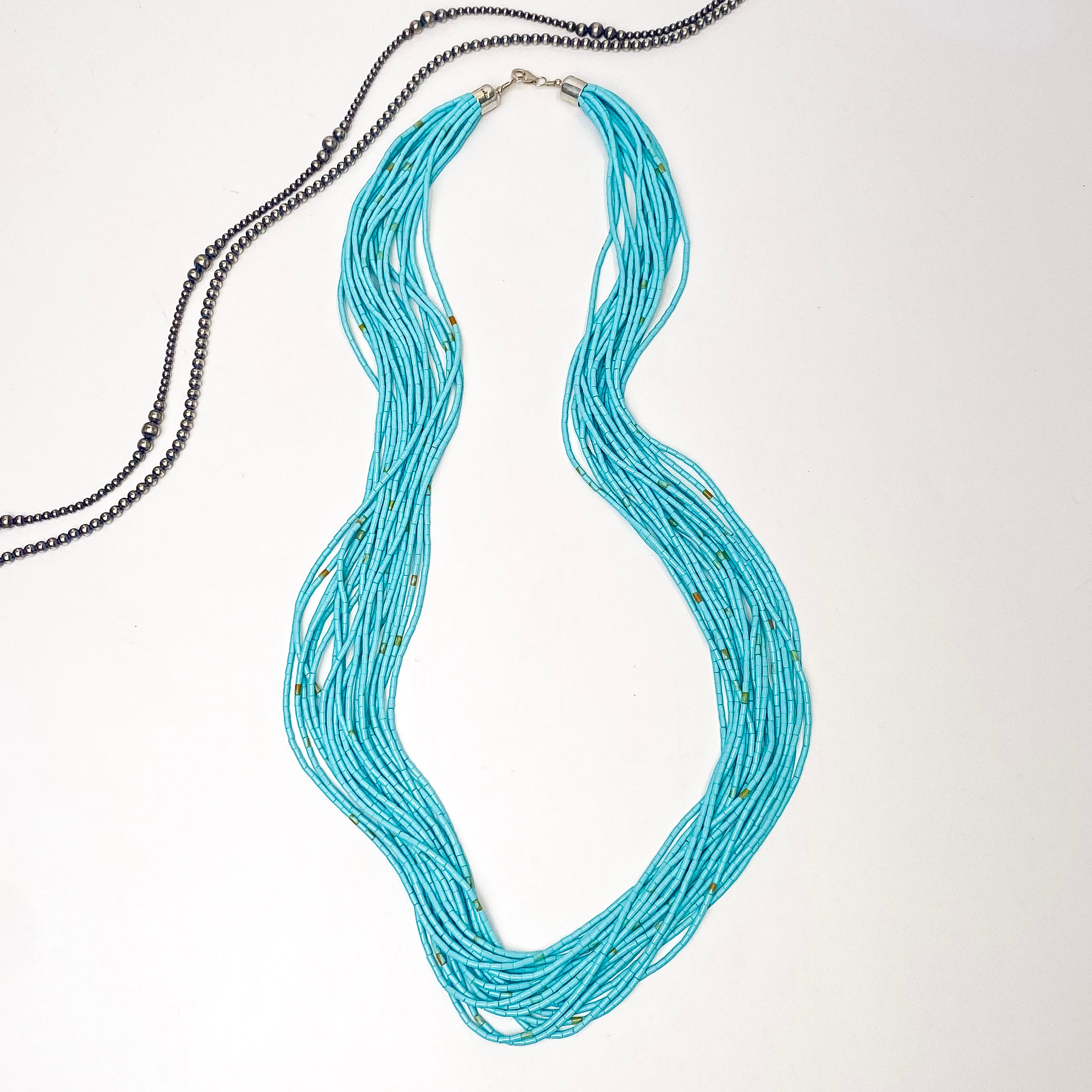 In the picture is a 20 strand turquoise necklace with heishi beads with a white background