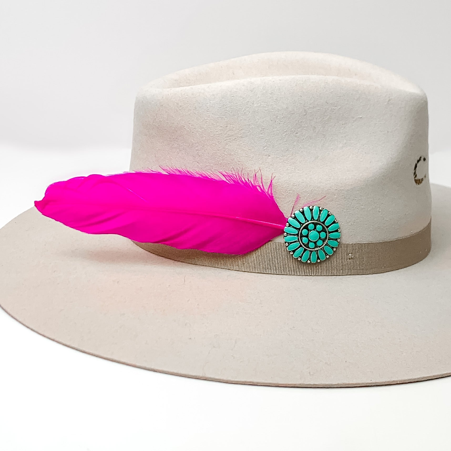 Turquoise Concho and Pink Feather Hat Pin. Pictured on a white background with the pin in a gray/ brown hat.