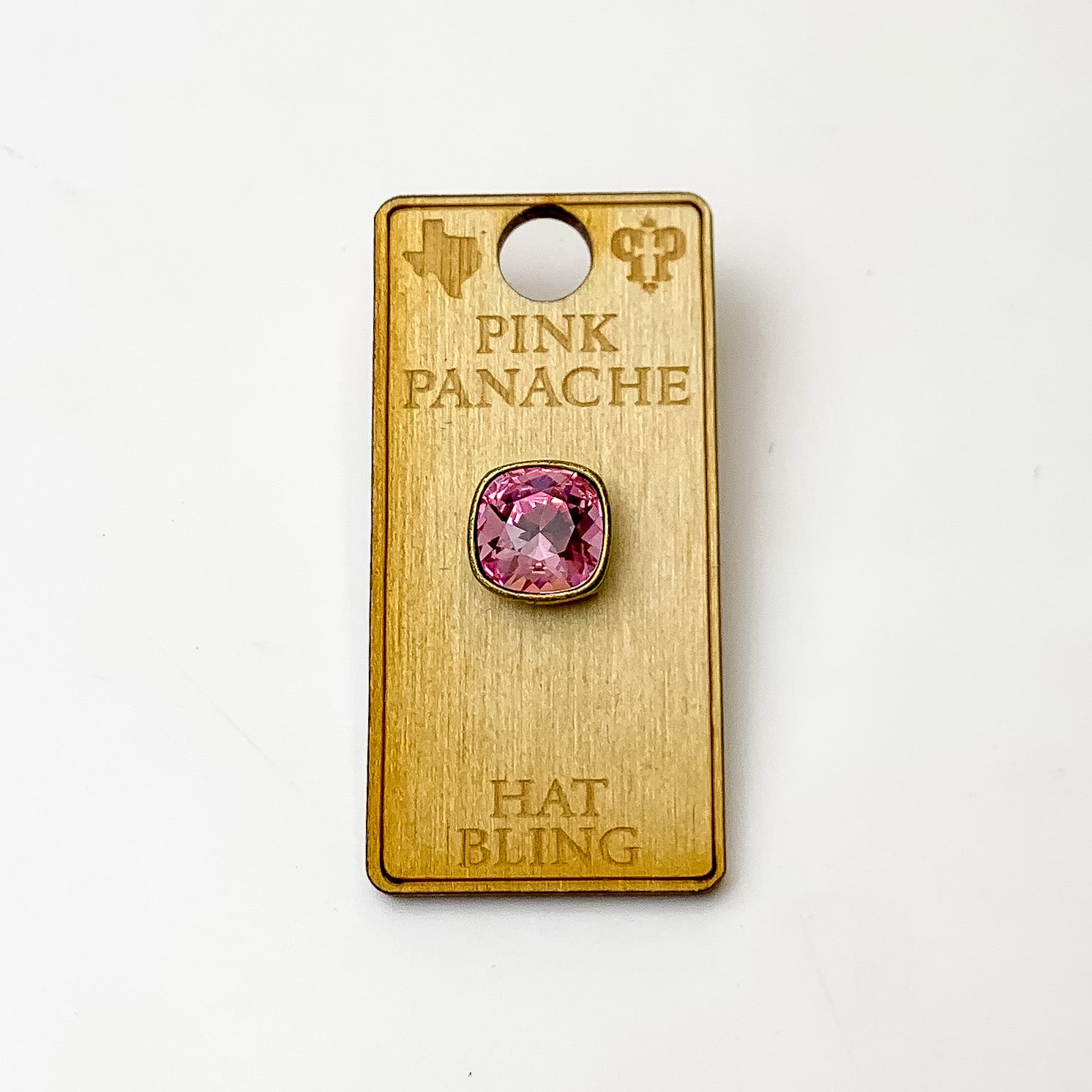 Bronze, square hat pin with a light rose cushion cut crystal. This hat pin is pictured on a wooden Pink Panache holder on a white background.