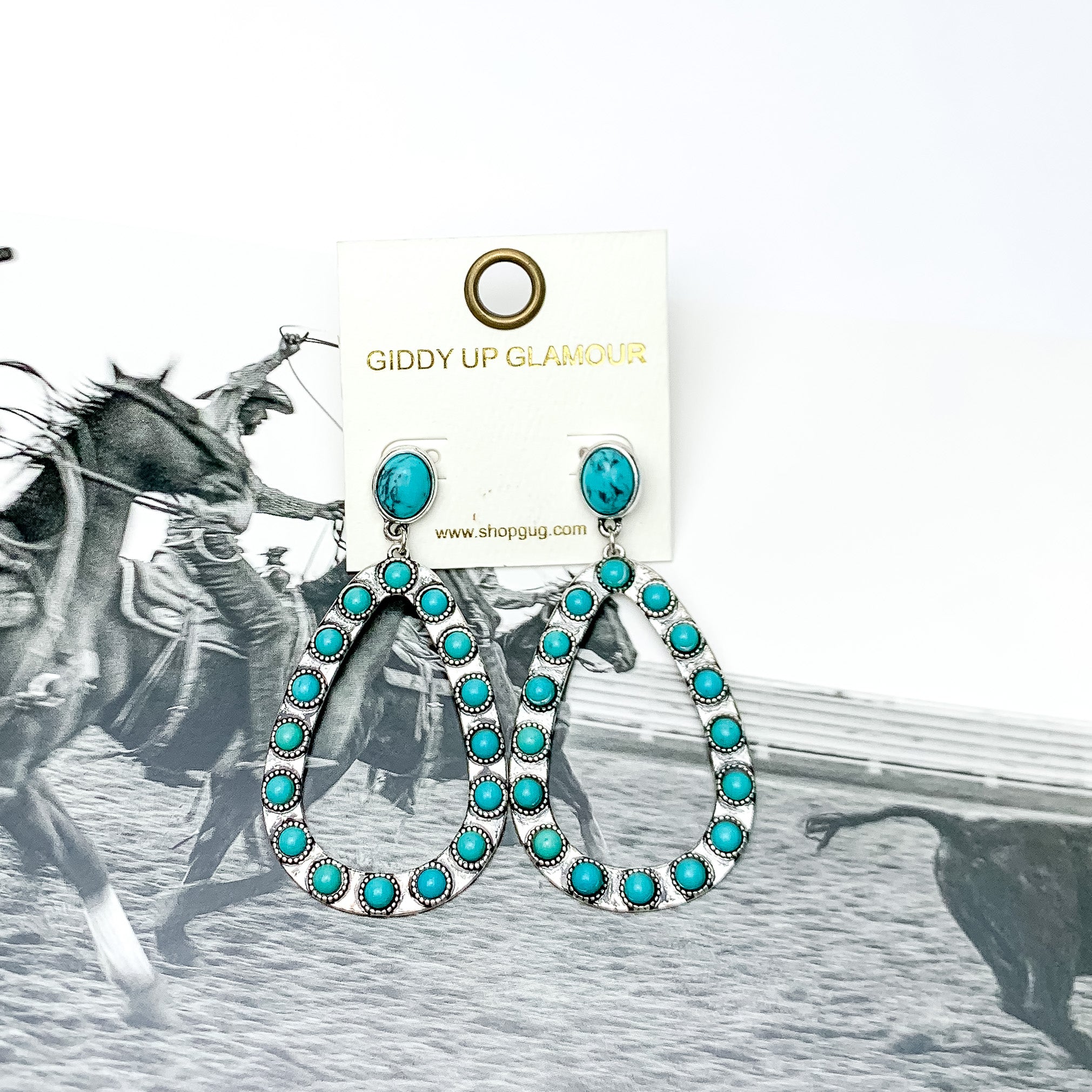 Western Open Teardrop Earrings With Stones in Turquoise. Pictured on a western background picture.