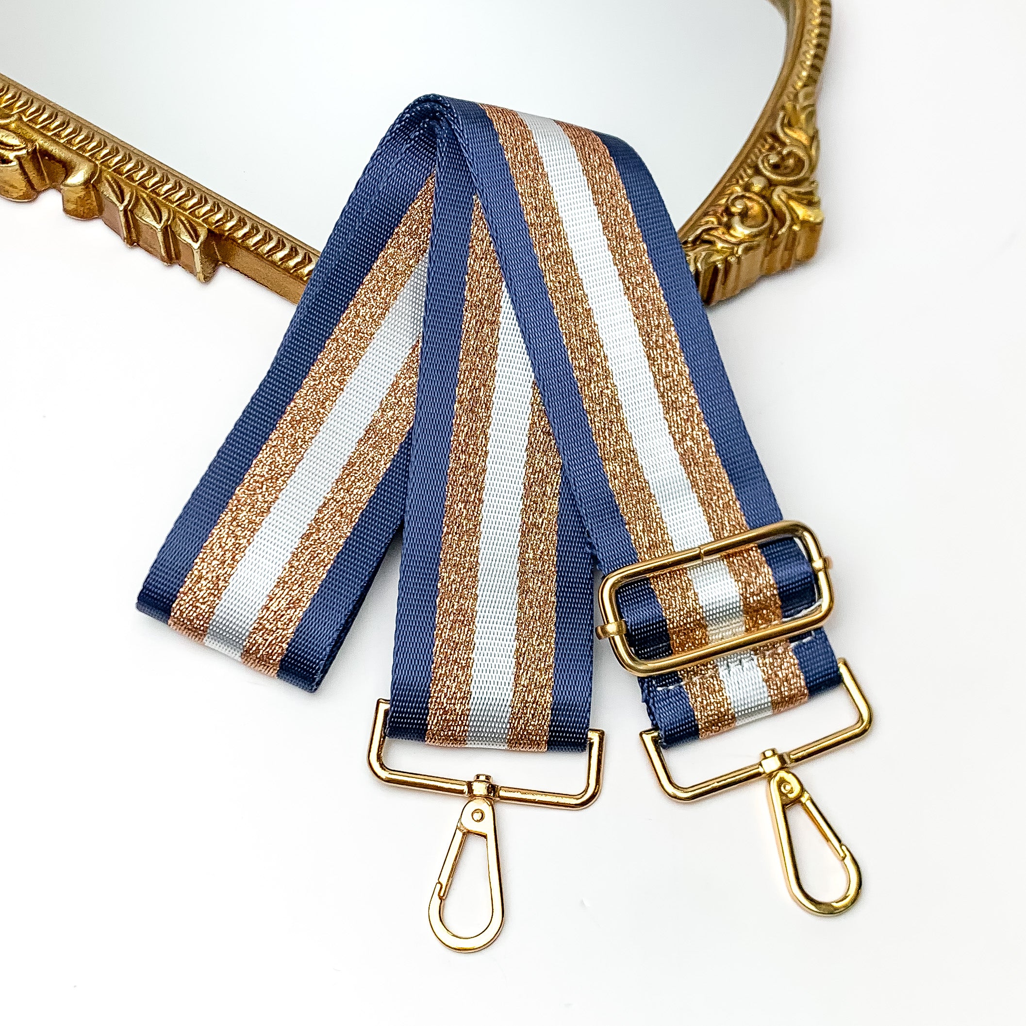 Striped Adjustable Purse Strap in Navy Blue. This bag strap is on a white background with a gold trimmed mirror in the top corner.