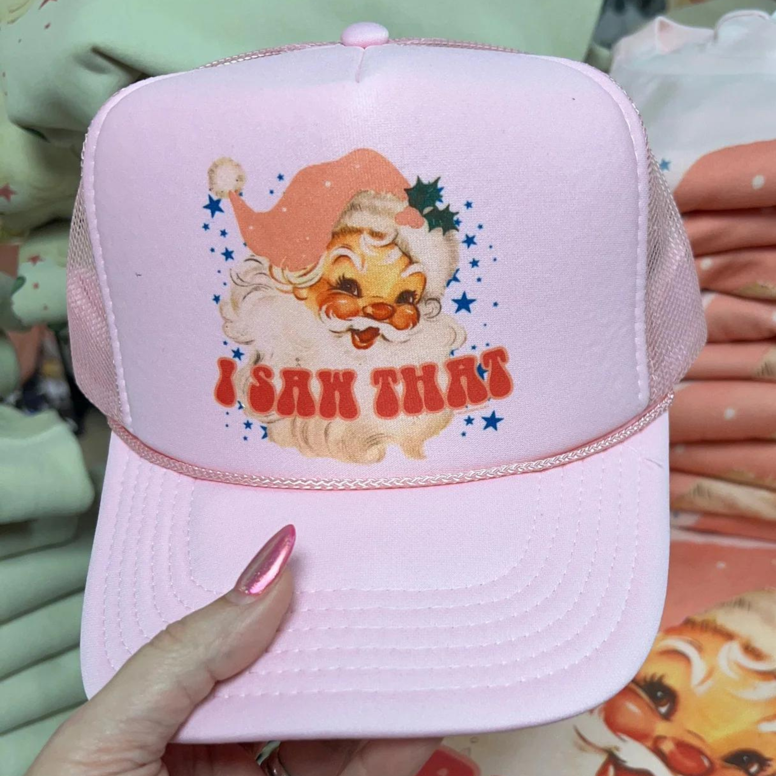 Photo features a light pink trucker hat that says "I Saw That" with a picture of Santa on the front.