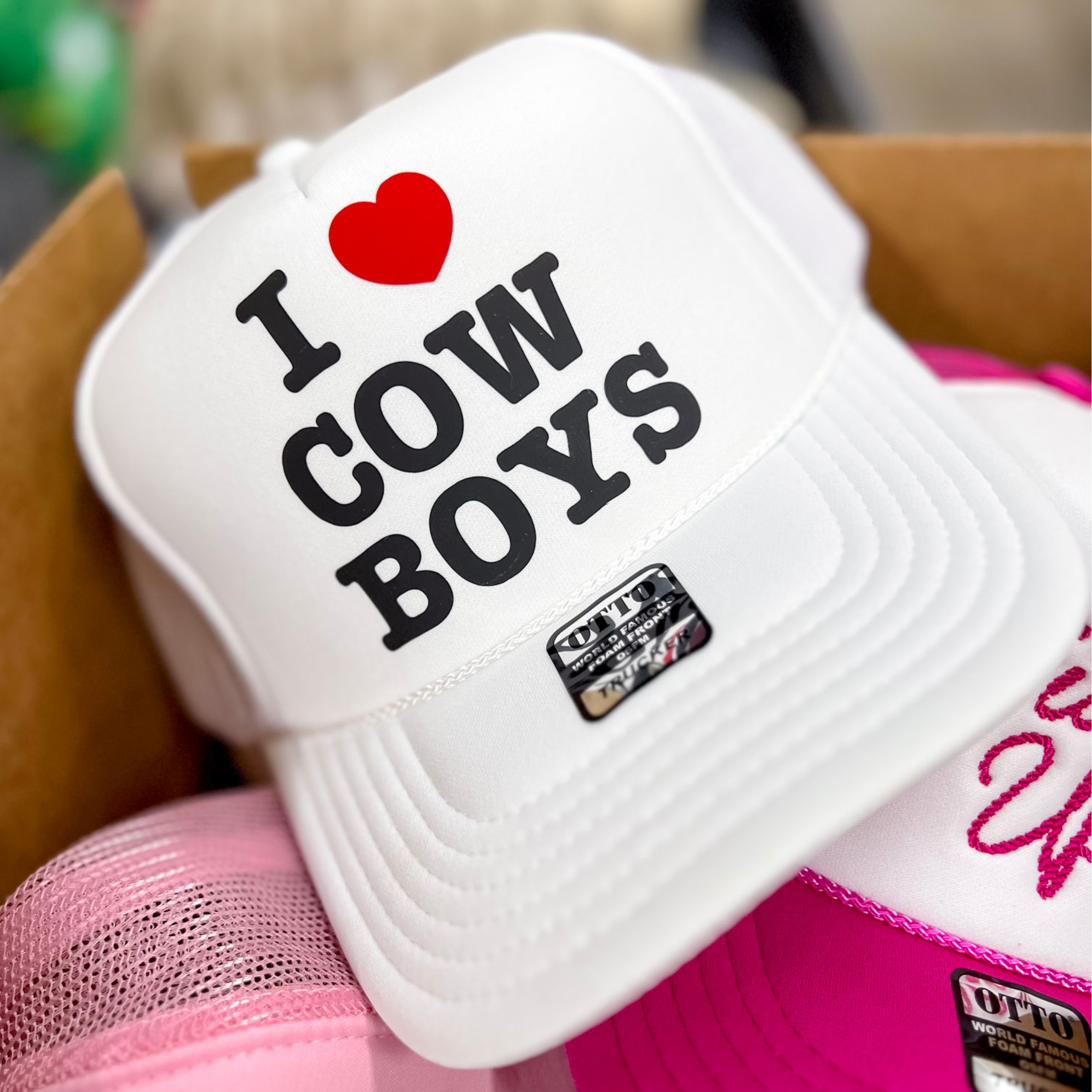 Photo features a white trucker hat with the words "I heart cowboys" in black on the front.