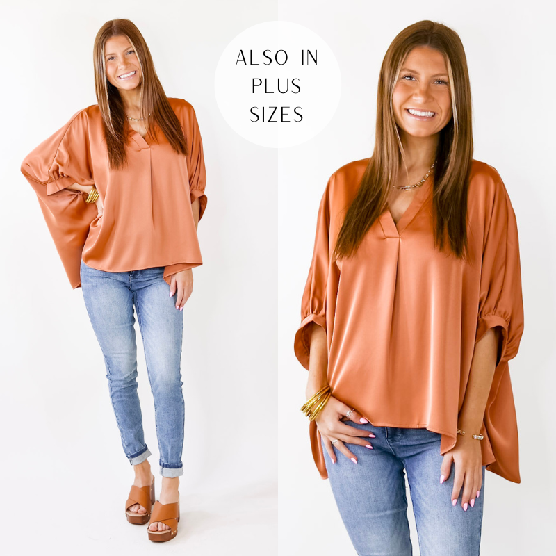 Model is wearing a copper v neck top with light blue jeans, brown sandals, and gold jewelry. 