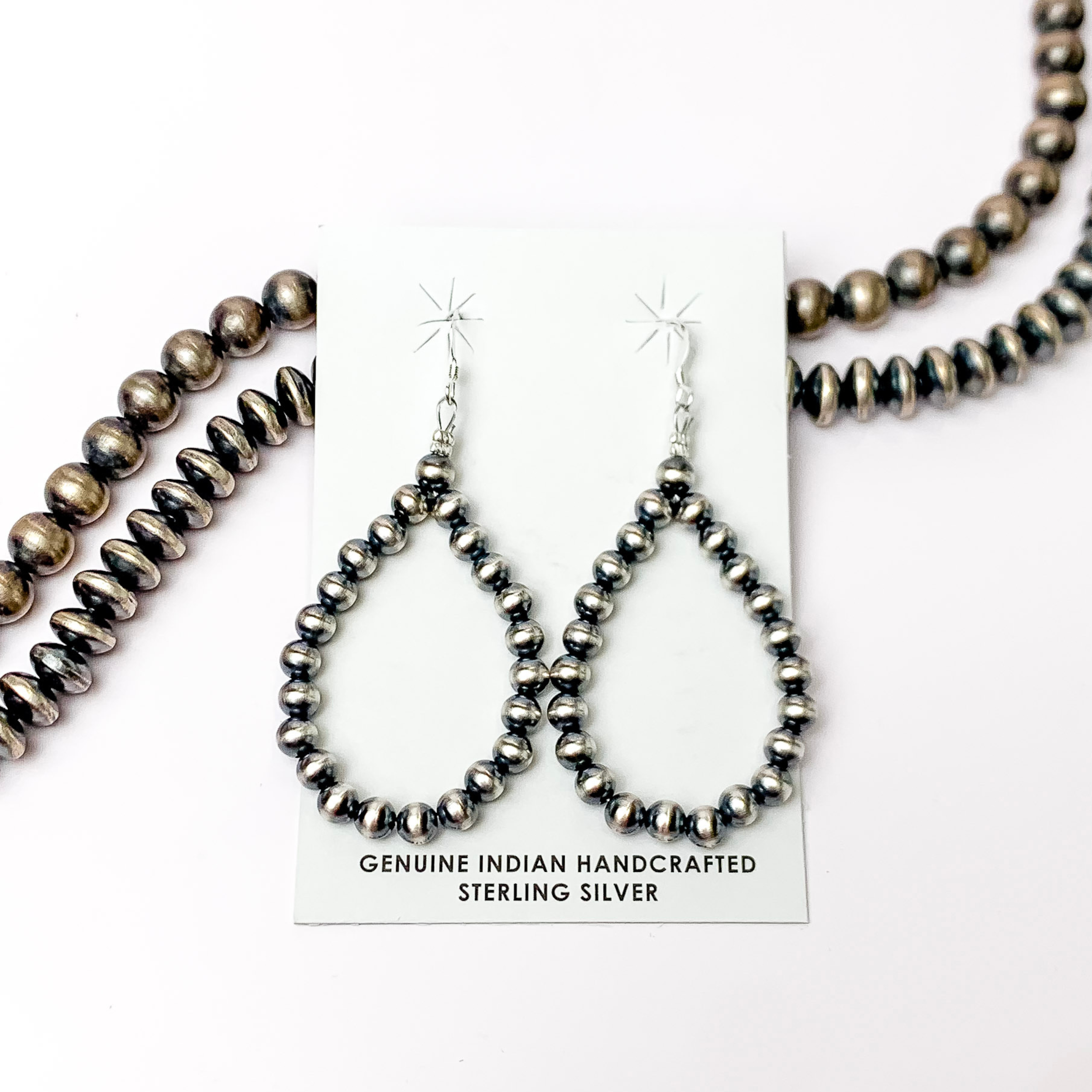 Centered in the picture Navajo pearl drop earrings with a white background.  