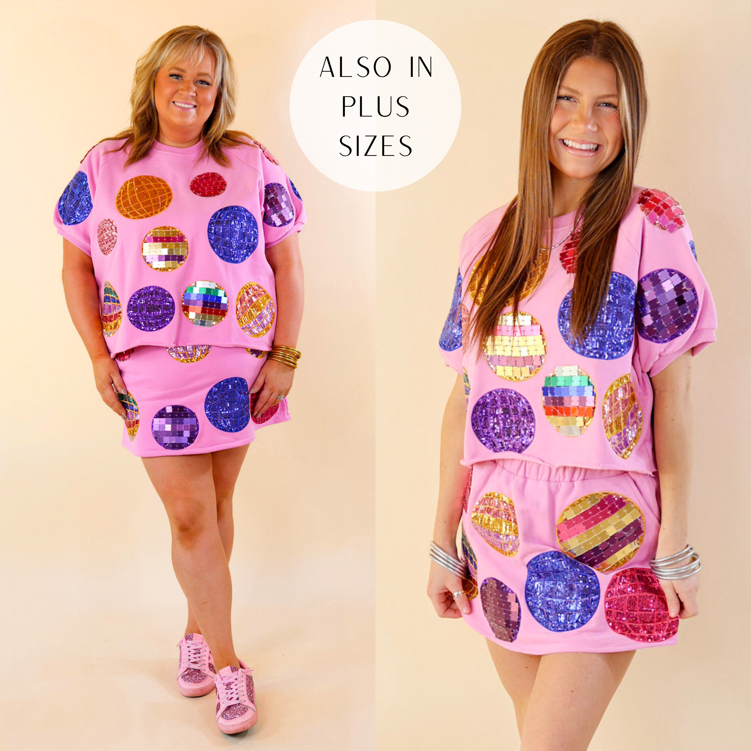 Models are wearing a short sleeve disco ball graphic top in pink. Size plus model has it paired with the matching skort, pink Vintage Havanas and gold jewelry. Size small model has it paired with the matching skort and silver jewelry. 