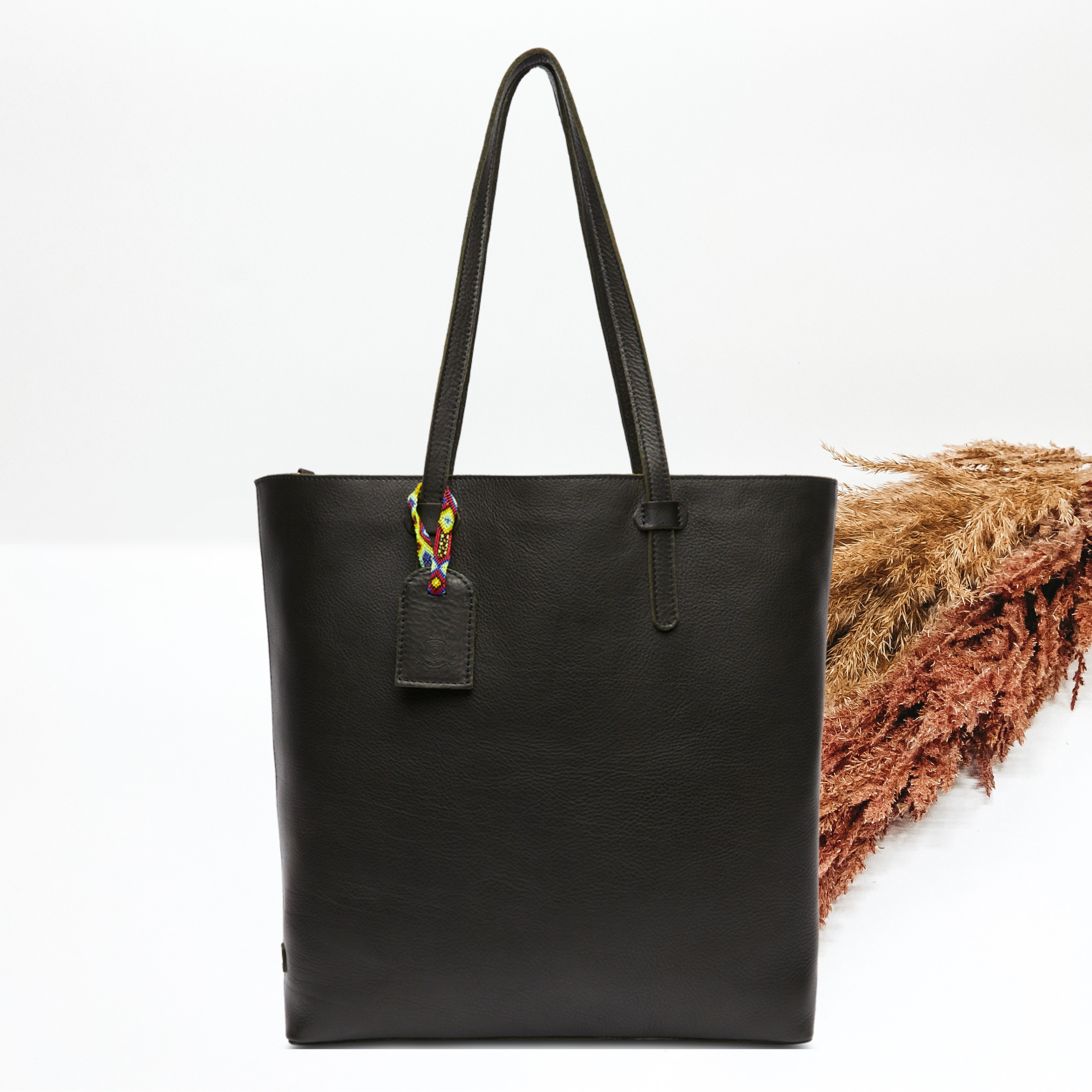 Pictured on a white background is black leather market tote. 
