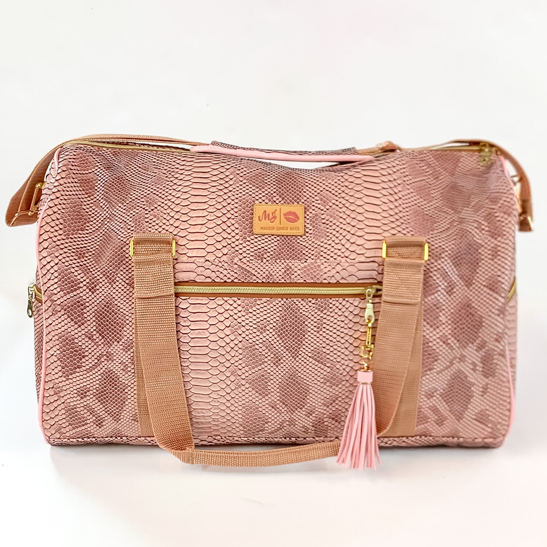 Pictured on a white background is a duffel bag with light tan straps in a copper snake print. This bag includes a zipper tassel, two short light tan straps, and a long light tan strap.