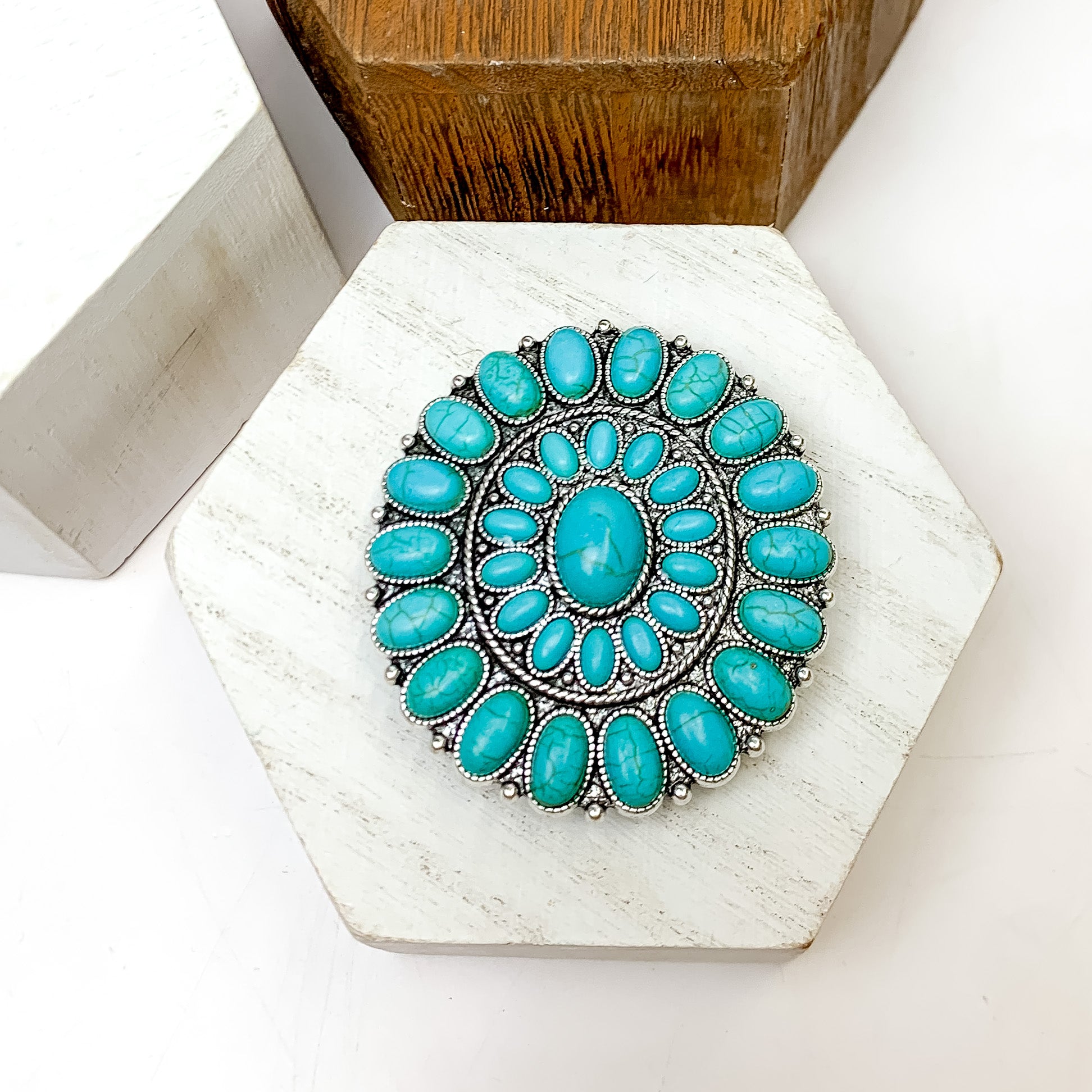 Silver Tone And Turquoise Stone Circle Phone Grip. This phone grip is pictured on a white block with a white background behind it.