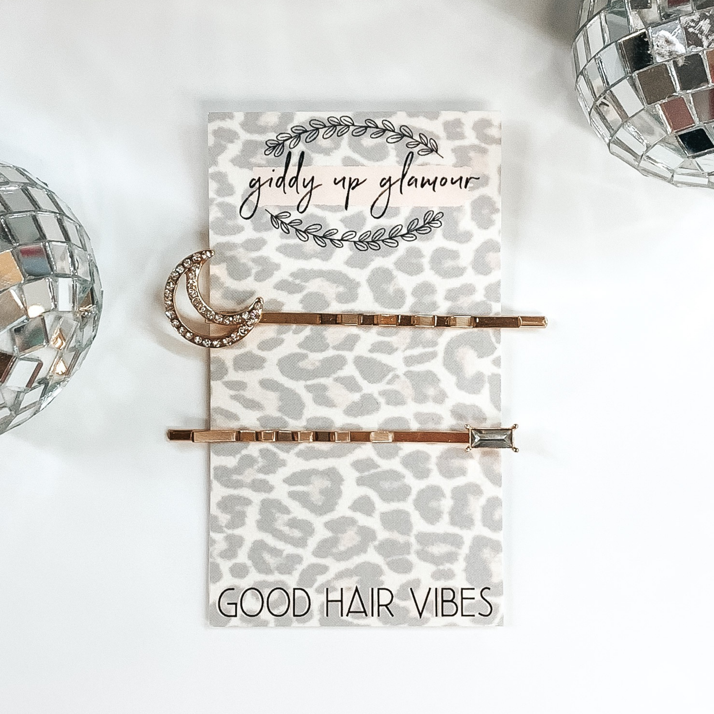 gold hair pins; one with a moon and one with a baguette