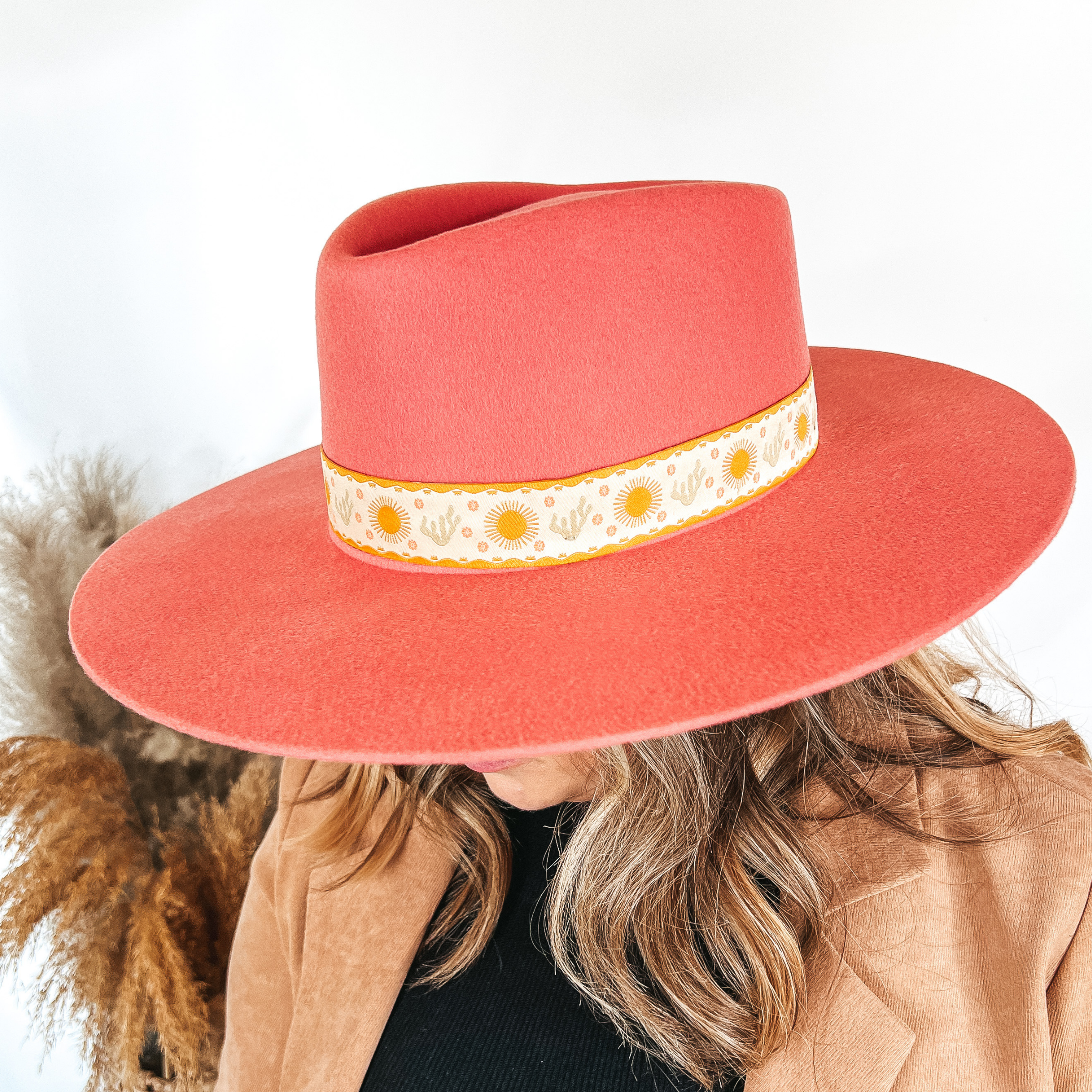 Model is wearing a coral pink with a sun and cactus hat band.