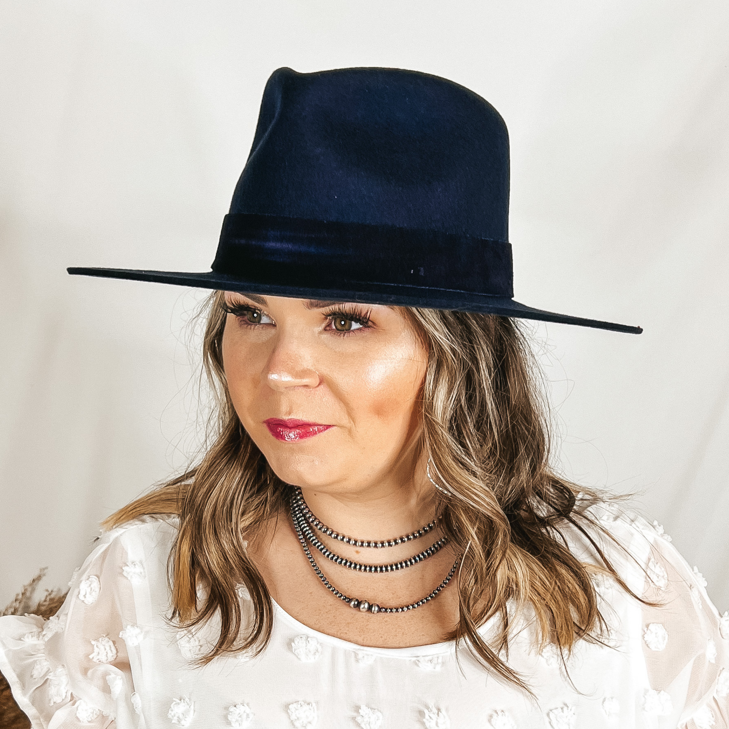 Model is wearing a navy blue rancher hat with a velvet hat band.