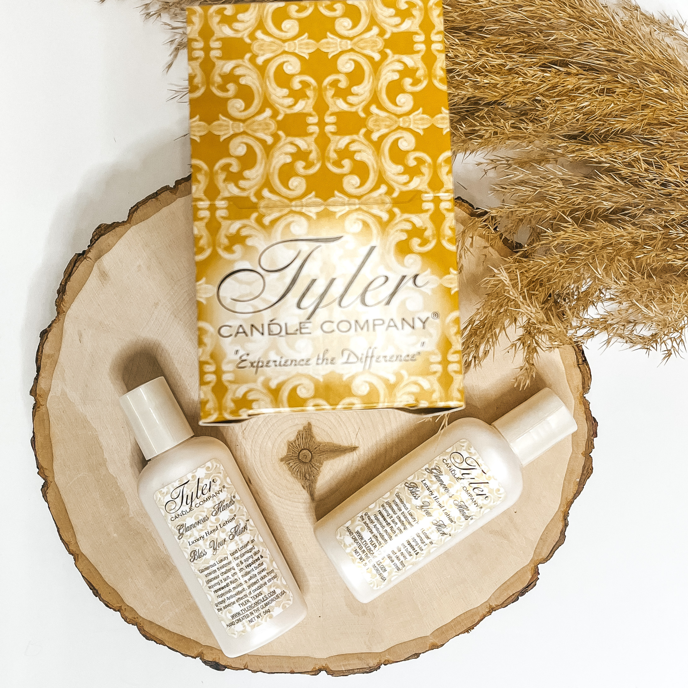 Glamourous hand lotion pictured in 2 oz size of Bless Your Heart scent pictured on tree wood with a Tyler logo.