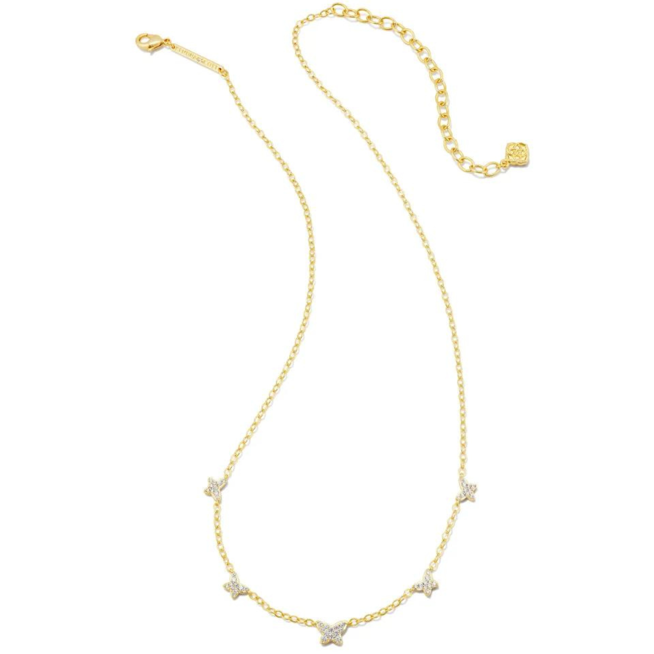 Gold necklace with five tiny white crystal butterflies, pictured on a white background.