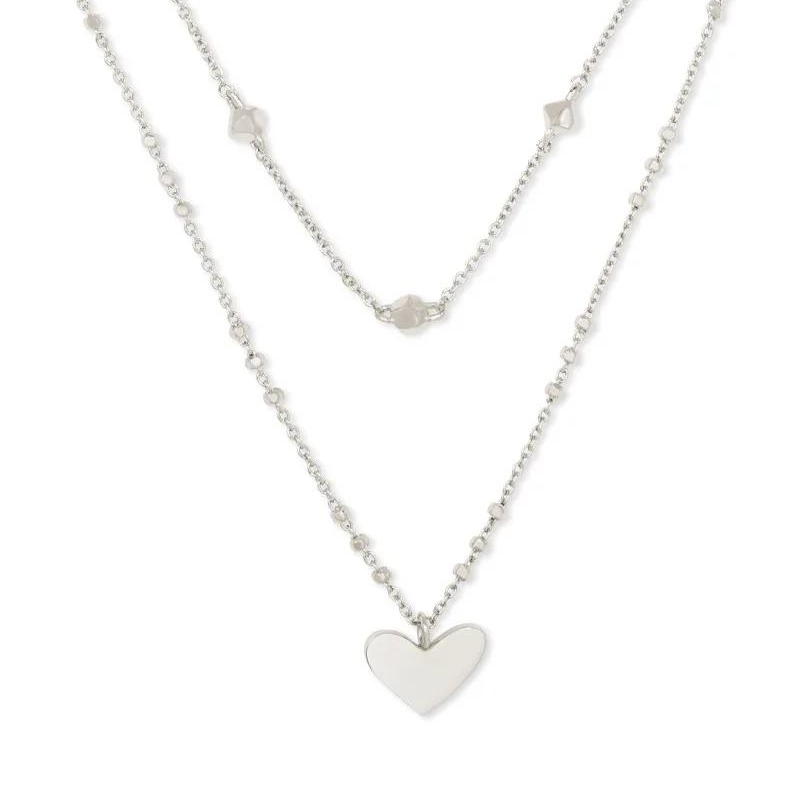 Silver multi layerd necklace with a heart pendant, pictured on a white background.