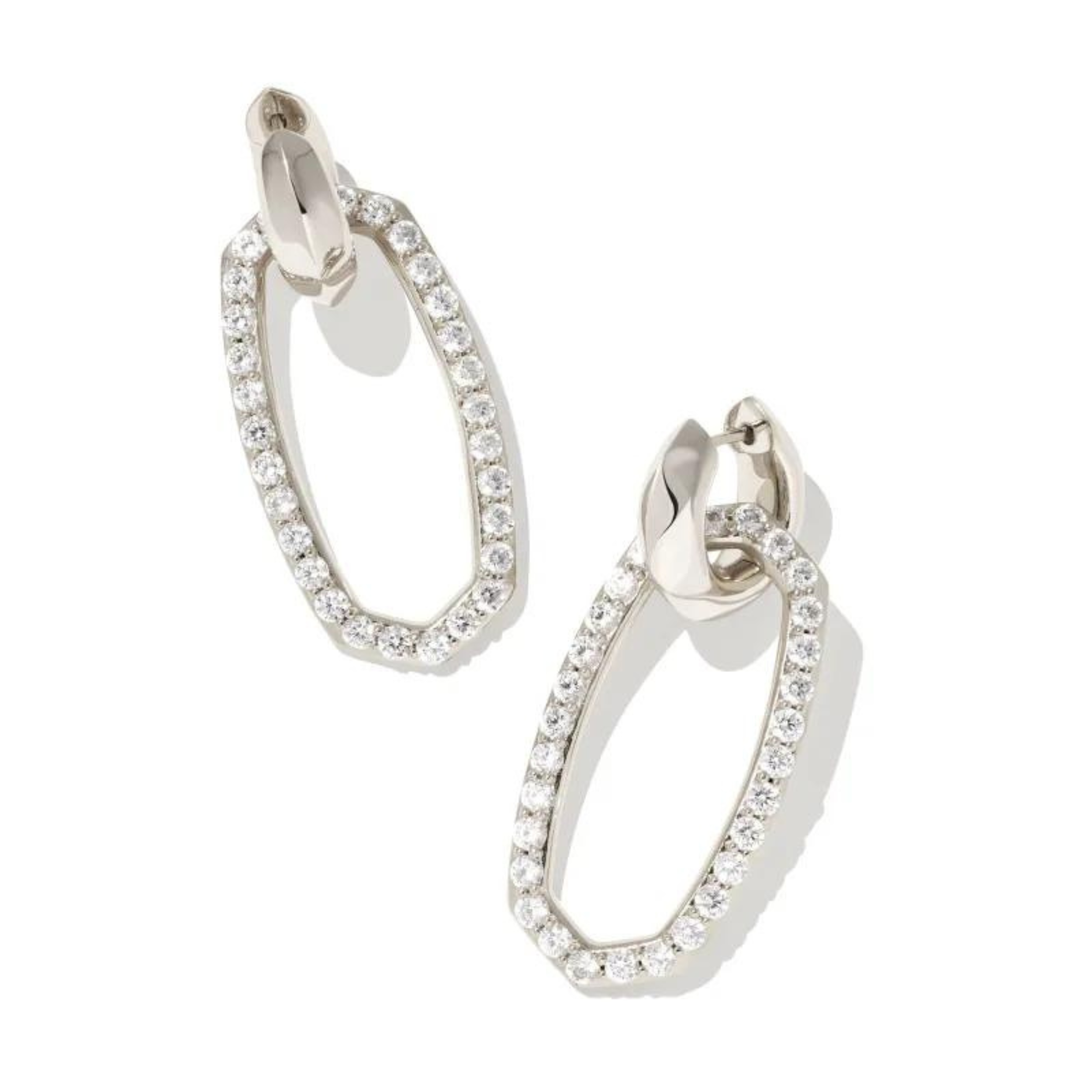 Silver hoop dangle earrings with white crystals pictured on a white background. 