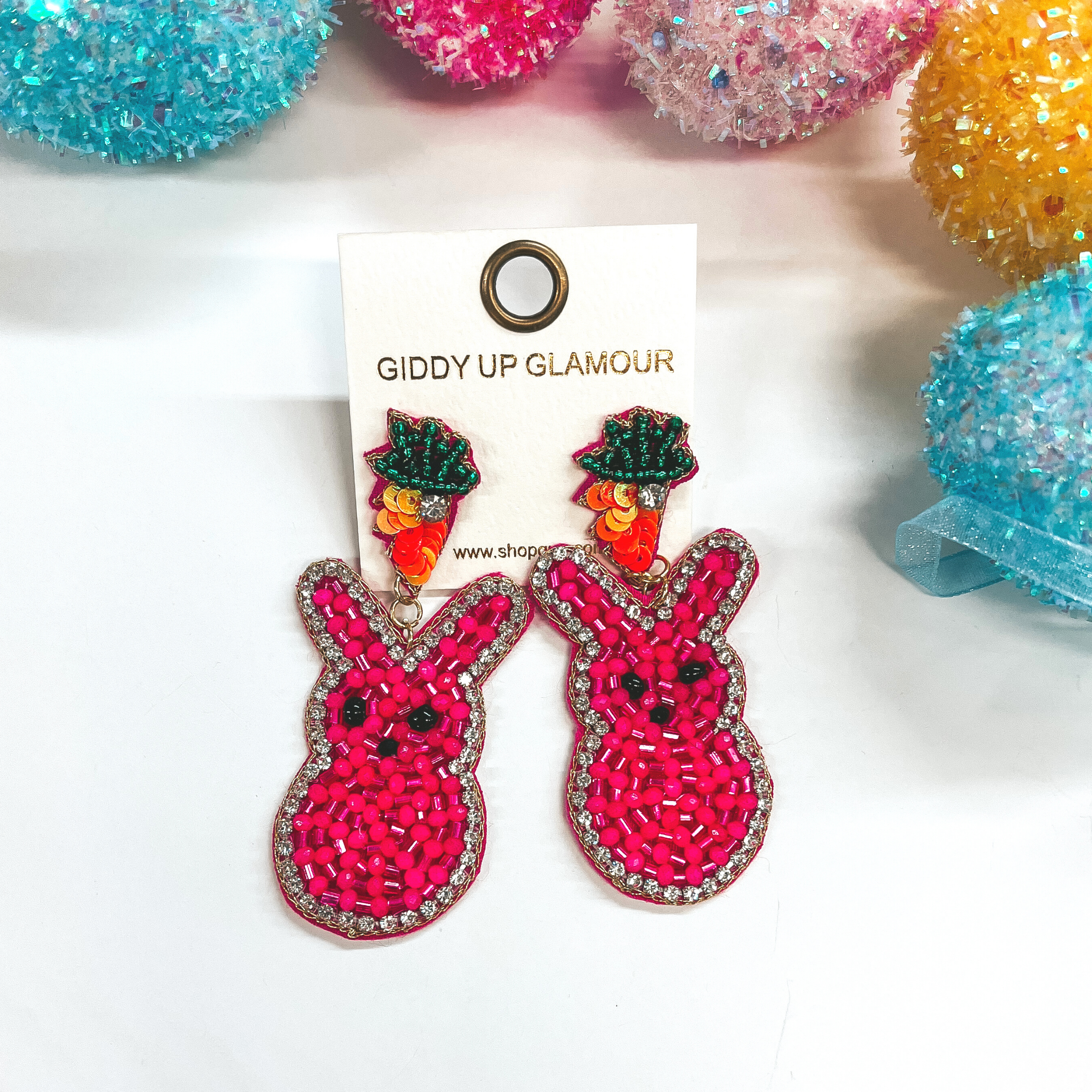 Beaded bunny rabbit earrings on a carrot post. Pictured on white background with colorful Easter eggs.