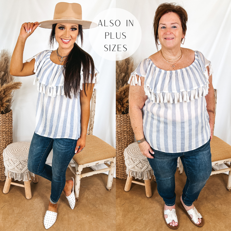 Models are wearing a blue and white striped top with ivory tassels. Size small model has it paired with skinny jeans, white mules, and a tan hat. Plus size model has it paired with skinny jeans, white sandals, and gold jewelry.