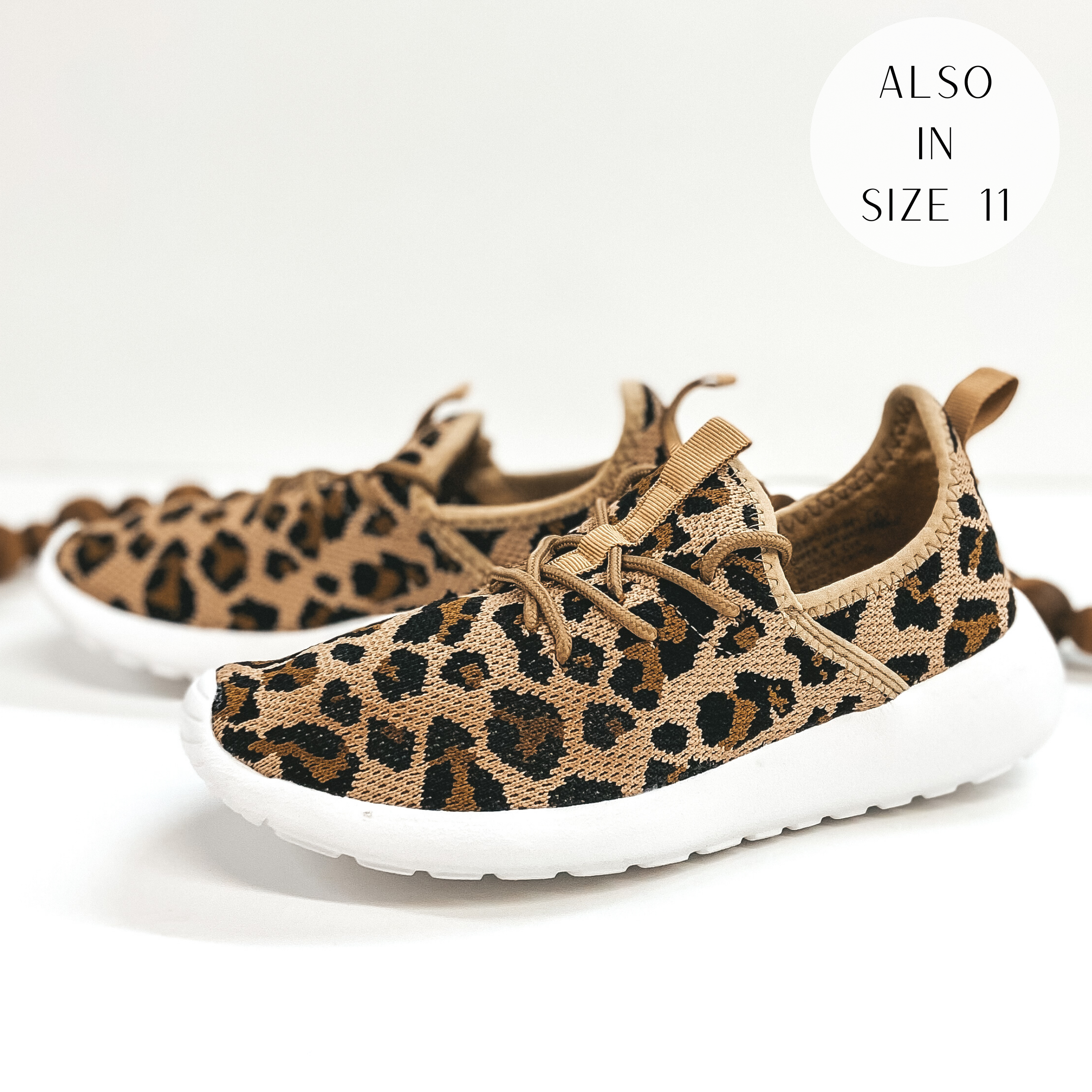 A pair of leopard print lace up sneakers. Pictured on white background with brown beads.