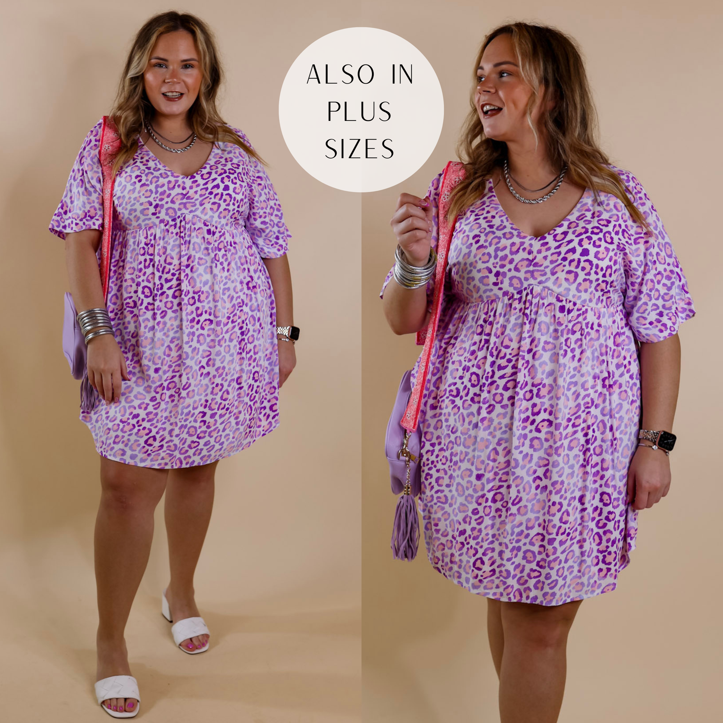 Model is wearing a knee-length babydoll style dress with short sleeves and a v neck. This dress is a purple leopard print pattern on an ivory background. Model has it paired with white sandals, silver jewelry, and a purple purse.