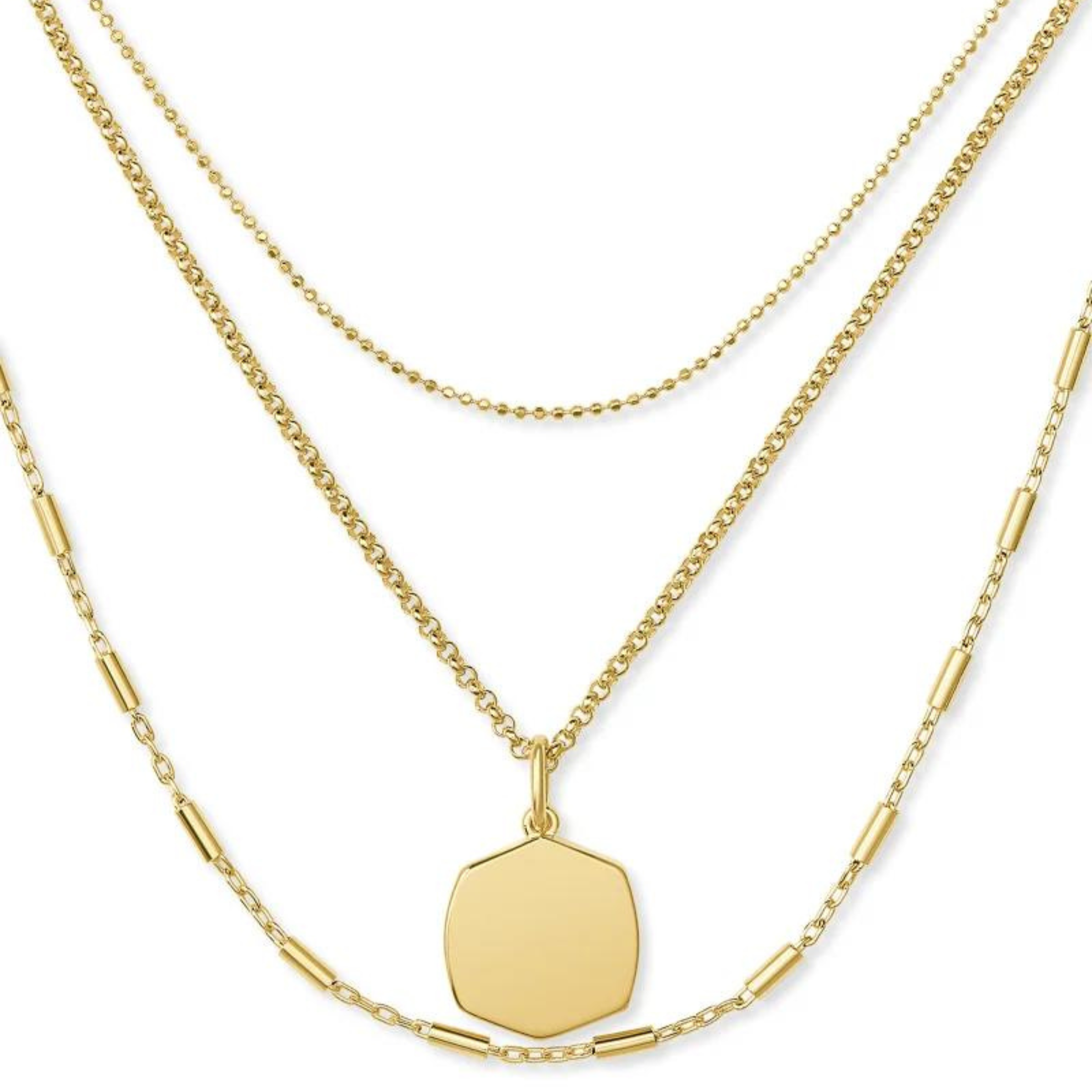 Three strands of gold chains. Each strand is different and the middle strand has a hexgonal shape pendant. This necklace is pictured on a white background. 