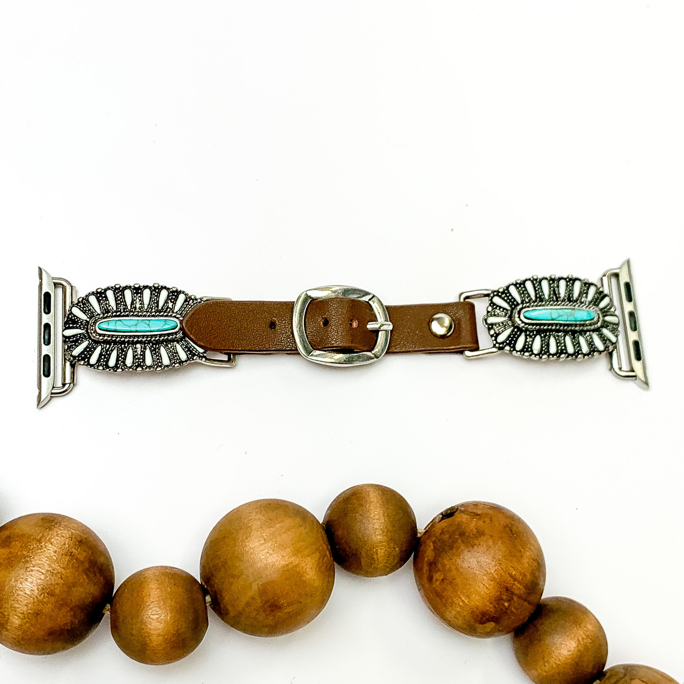 Dark Brown watch band with oval, stone cluster pendants and Apple watch band acessories. The pendants include mostly ivory stones with a center turquoise stone. This watch band is pictured on a white background with brown beads below the band. 