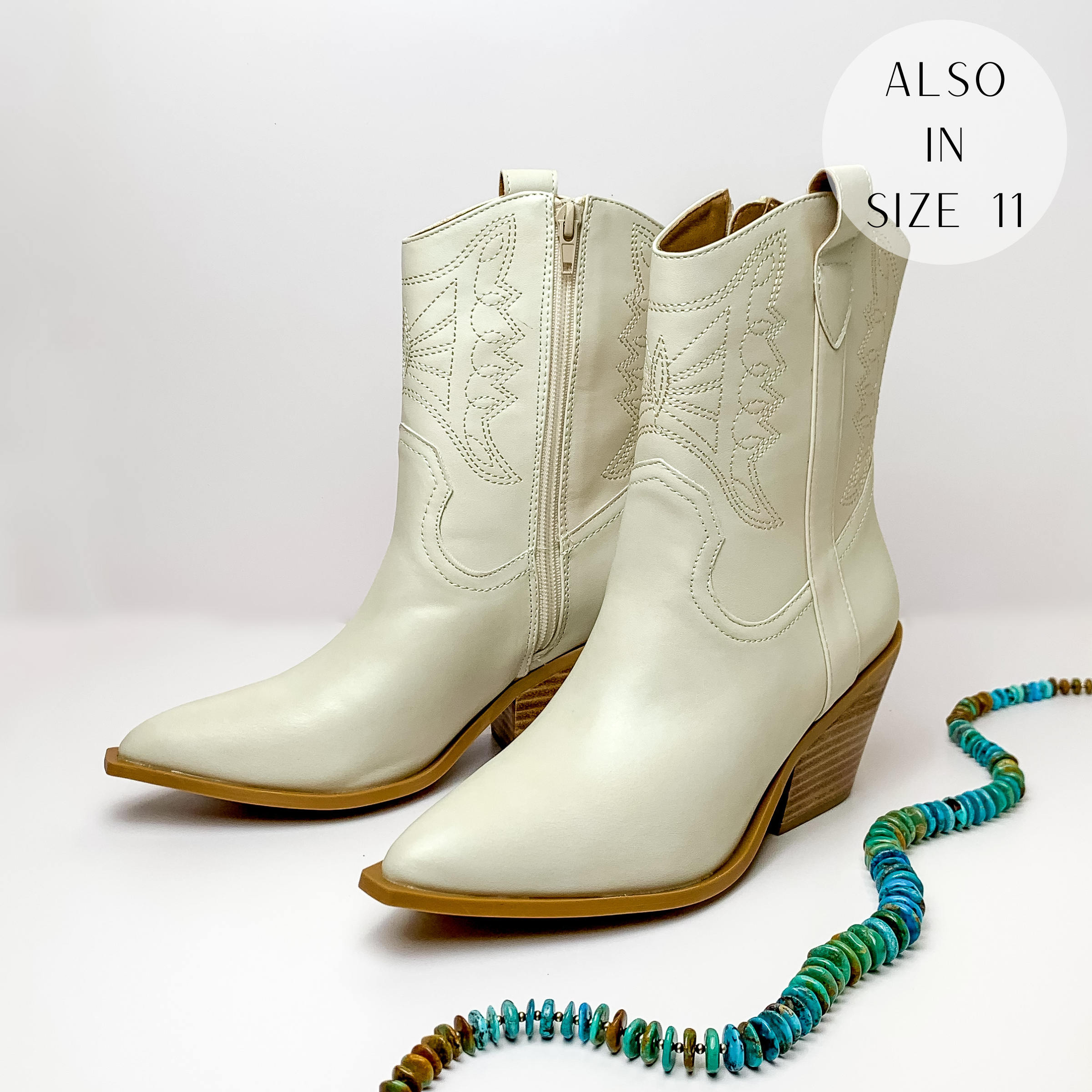 Bone white cowboy ankle boots with an ivory western stitching and tan heel. These boots are pictured on a white background with turquoise beads on the right side of the boots.
