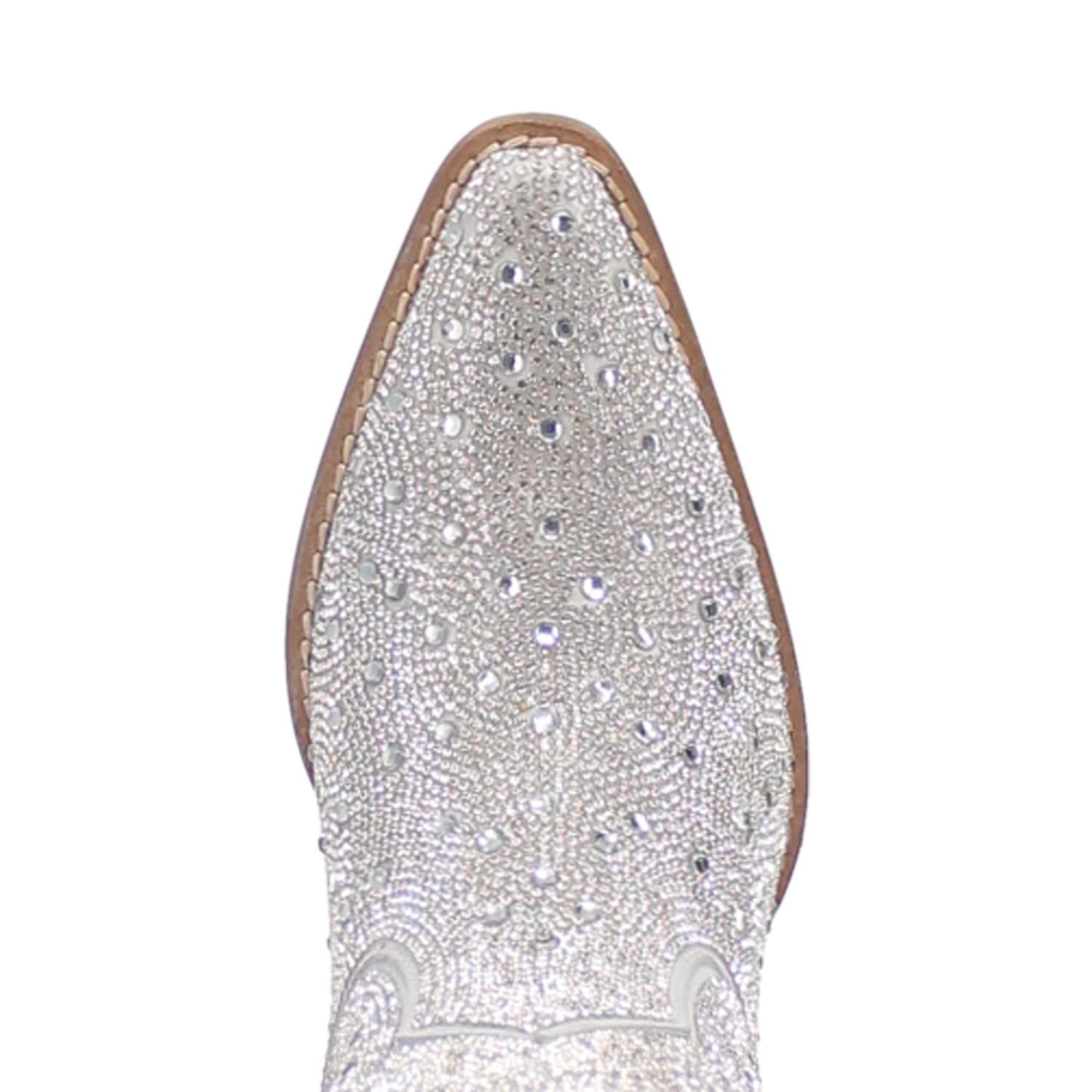 A mid calf length white boot with rhinestones from top to bottom, matching leather straps, a short heel, and a V cut at the top. Item is pictured on a white background