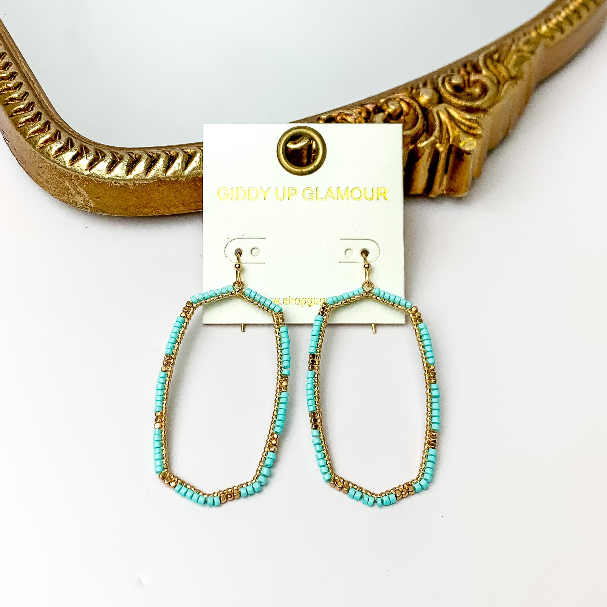 Turquoise Beaded Open Large Drop Earrings with Gold Tone Accessory. Pictured on a white background with a gold frame through it. 