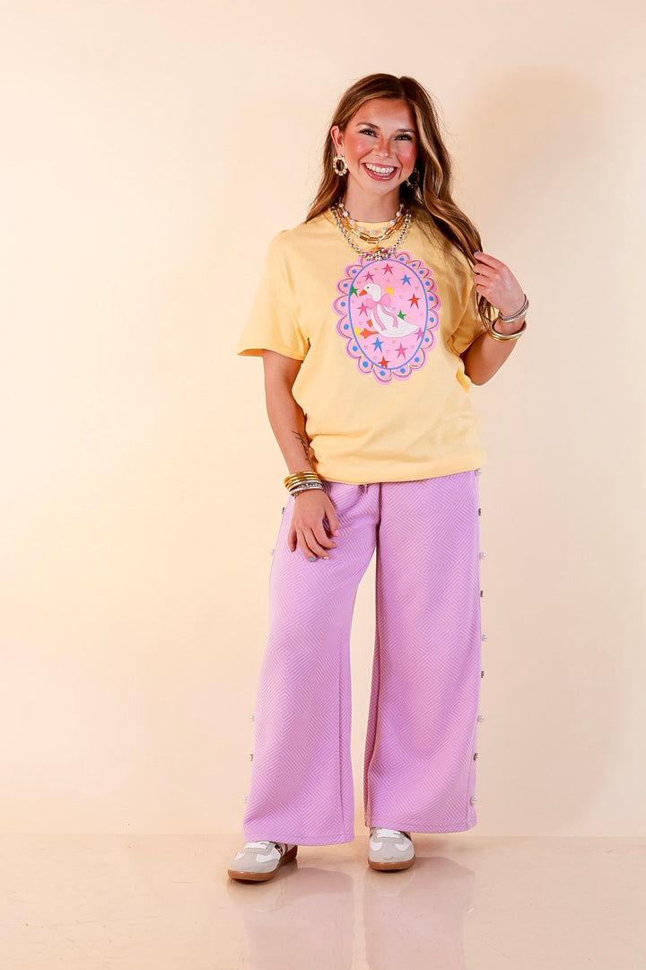 Goose on the Loose Whimsical Pink Background with Stars and Hearts Goose Printed Graphic Tee in Butter Yellow
