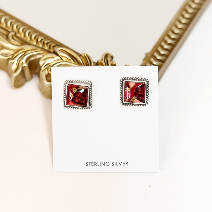 Square Navajo-made sterling silver earrings featuring bold red Rose Dahlia stones, handmade by Judith Dixon and displayed on a white card.