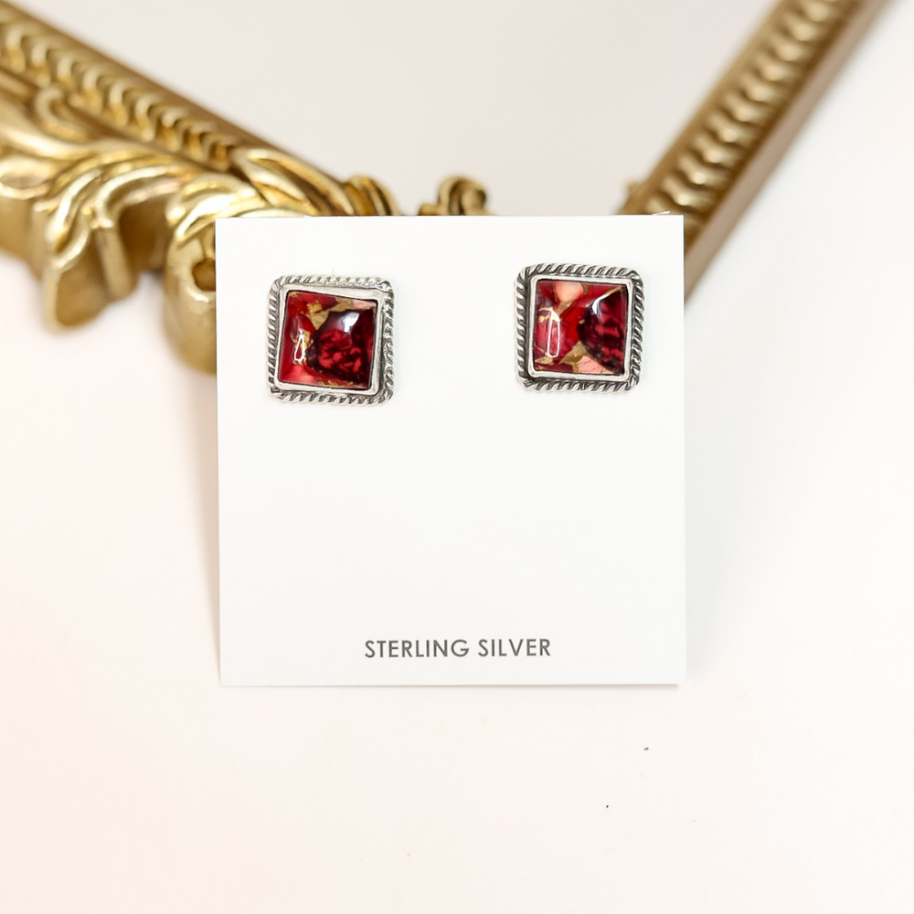 Square Navajo-made sterling silver earrings featuring bold red Rose Dahlia stones, handmade by Judith Dixon and displayed on a white card.