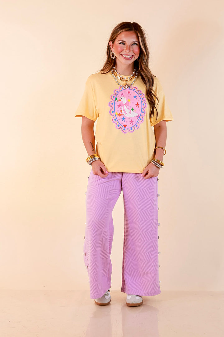 Goose on the Loose Whimsical Pink Background with Stars and Hearts Goose Printed Graphic Tee in Butter Yellow
