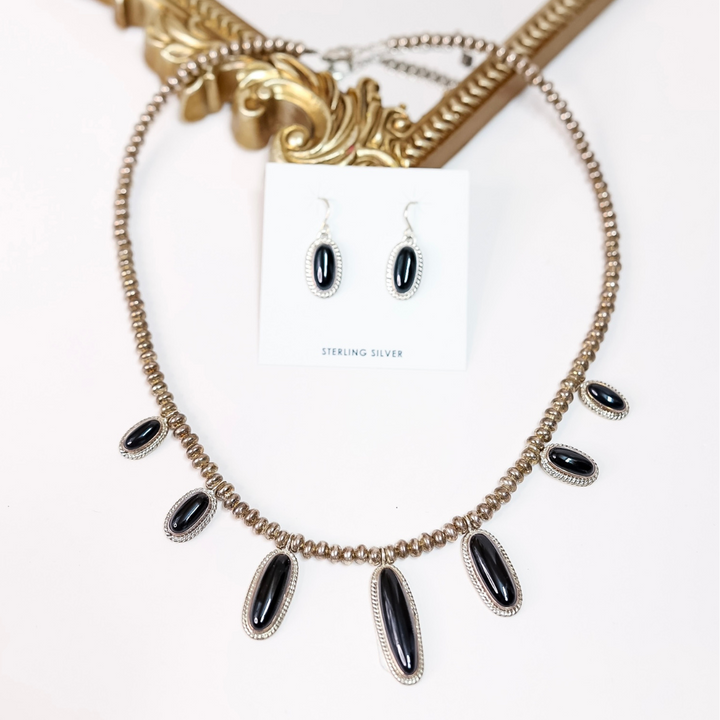 Necklace with black stones and matching earrings on a white background