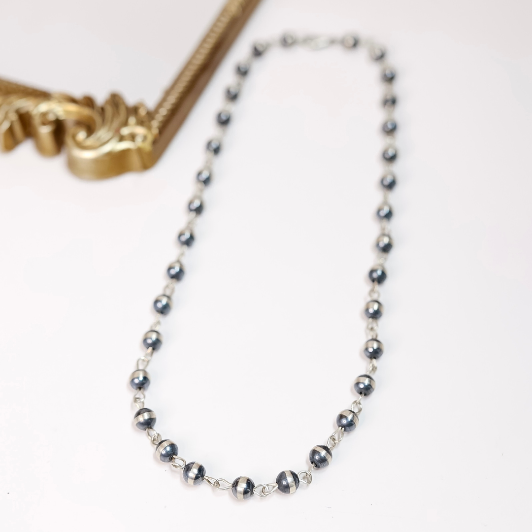 10mm sterling silver Navajo pearl chain link necklace styled as both a classic and lariat necklace on white background with gold frame accent.