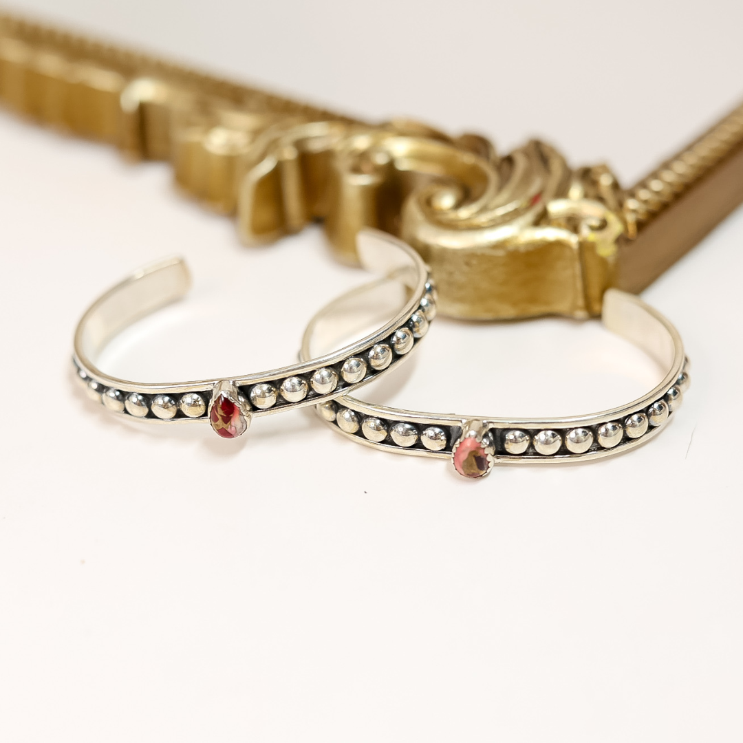 Two sterling silver adjustable cuff bracelets with teardrop-shaped Dahlia Rose stones and dotted detailing, handmade and stamped "HaDa"