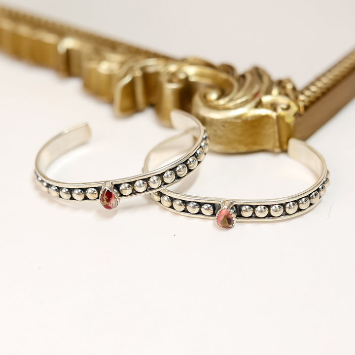 Two sterling silver adjustable cuff bracelets with teardrop-shaped Dahlia Rose stones and dotted detailing, handmade and stamped "HaDa"