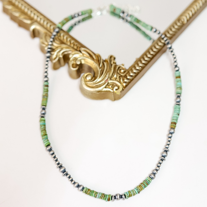 Handmade Red River Turquoise and Sterling Silver Navajo Pearl necklace styled flat with ornate gold frame; 20-inch length with 2-inch extender.