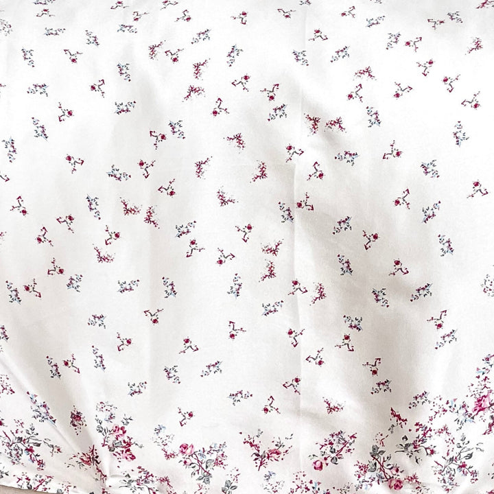 Floral-patterned blanket on a cushion of a wicker chair