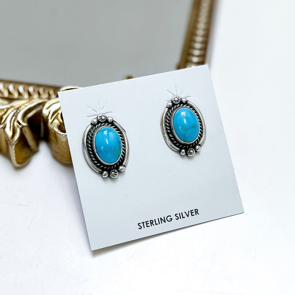 Sterling silver turquoise stud earrings handmade by Native American artist Freida Martinez with oval turquoise stones and detailed western silverwork.