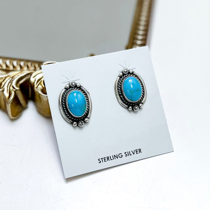 Sterling silver turquoise stud earrings handmade by Native American artist Freida Martinez with oval turquoise stones and detailed western silverwork.
