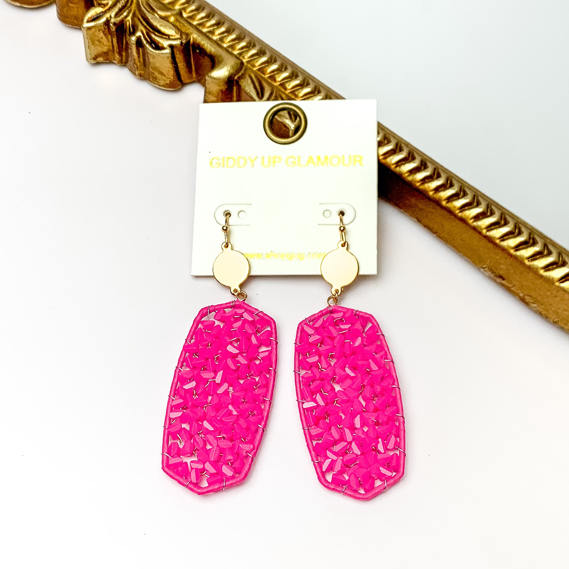 Hot Pink Large Drop Earring with Gold Tone Accessory. Pictured on a white background with a gold frame through it.