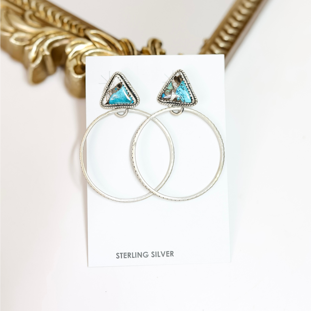 Pair of hoop earrings with triangle-shaped turquoise stones on a white card, with 'STERLING SILVER' text.