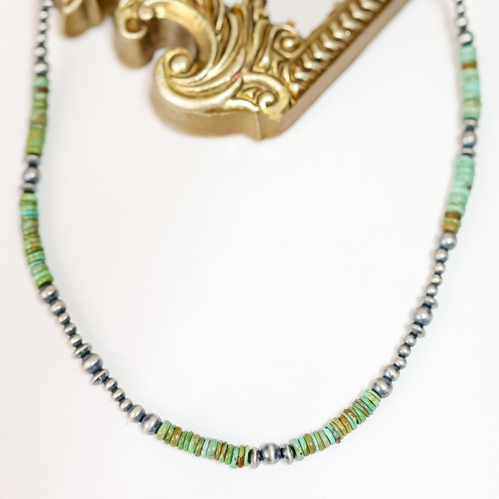 Handmade Red River Turquoise and Sterling Silver Navajo Pearl necklace styled flat with ornate gold frame; 20-inch length with 2-inch extender.