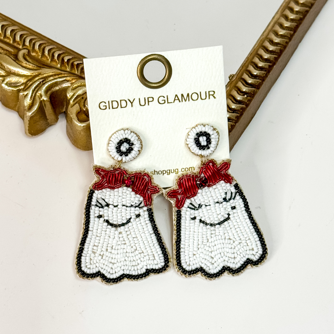 Beaded Halloween ghost earrings with smiling faces and red bow detail, lightweight statement jewelry.