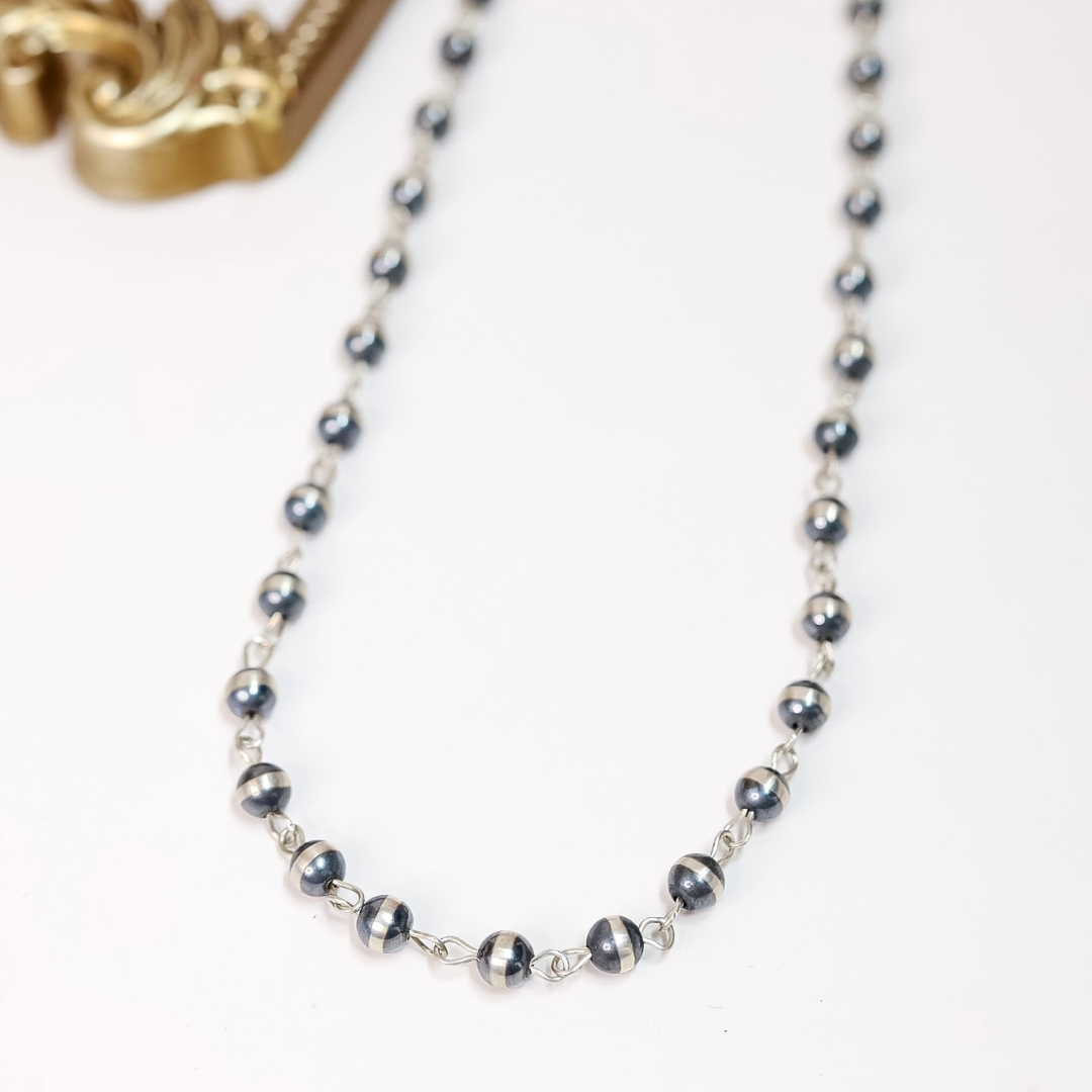 10mm sterling silver Navajo pearl chain link necklace styled as both a classic and lariat necklace on white background with gold frame accent.