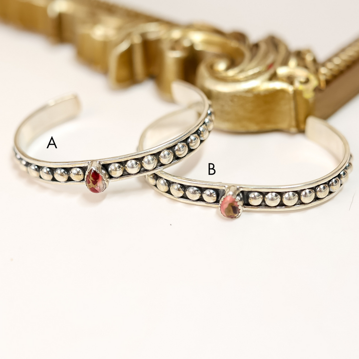 Two sterling silver adjustable cuff bracelets with teardrop-shaped Dahlia Rose stones and dotted detailing, handmade and stamped "HaDa"