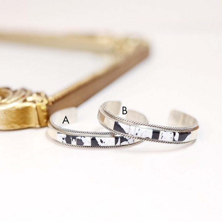 Two silver bracelets with different patterns on a white background