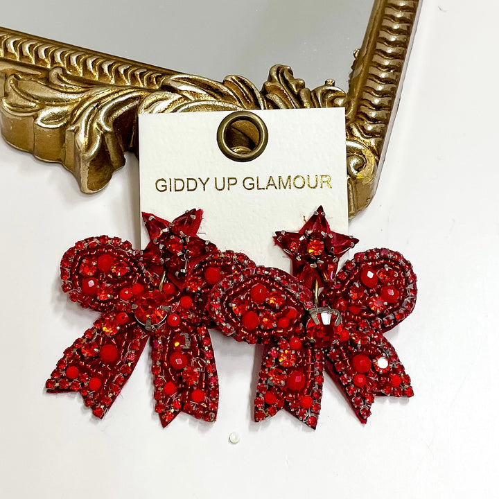 Red decorative brooches on a 'Giddy Up Glamour' card with a gold frame in the background.
