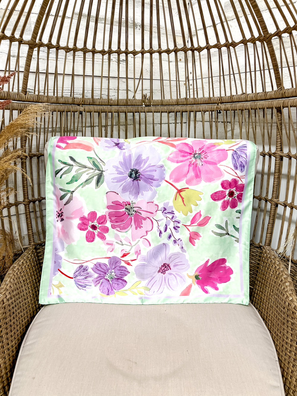 Floral-patterned scarf laid on a wicker chair